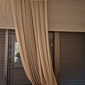 תריסים וחלון עם וילון בהיר