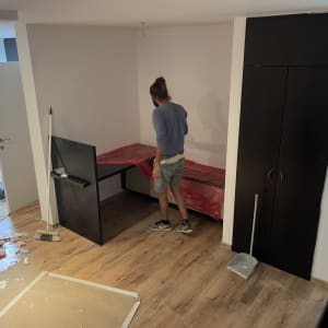 אדם מכסה שולחן בניילון אדום במהלך שיפוץ