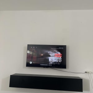 טלוויזיה תלויה על קיר עם כבלים חשמליים