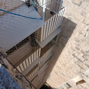 רשת יונים מותקנת על מבנה למניעת כניסת יונים