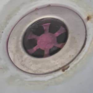 ניקוז כיור עם סימני חלודה סביב הפתח