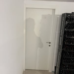 דלת לבנה עם ידית מתכת, קיר לבן