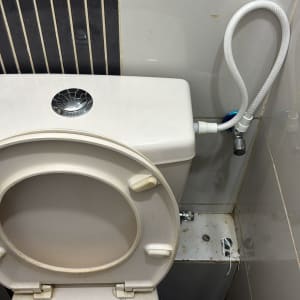 אסלה עם צינור מים מחובר לקיר