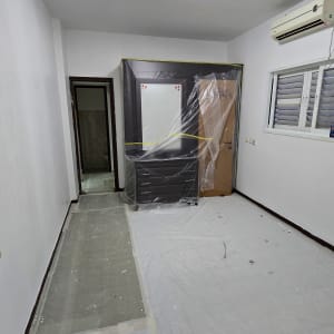 חדר עם רהיטים מכוסים בניילון לקראת צביעה