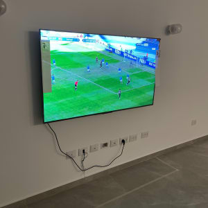 טלוויזיה תלויה על קיר גבס עם חוטים חשופים