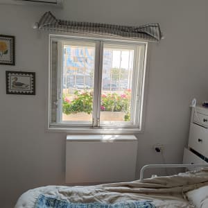 חלון עם תריסים לבנים פתוחים חלקית