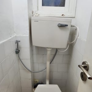 אסלה ומיכל הדחה בחדר שירותים קטן