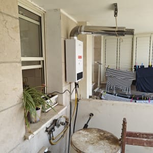 יחידת גז מחוברת לצינור מתכת על קיר חיצוני