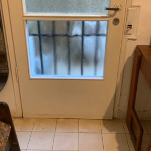 דלת לבנה עם פאנלים של זכוכית אורנמנטלית מחוספסת