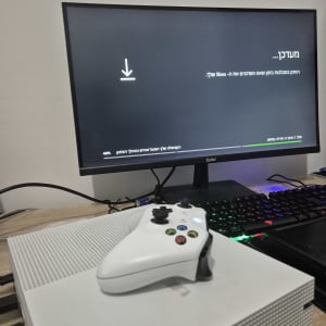 מסך מחשב עם עדכון, שלט וקונסולת משחקים