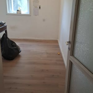 רצפת פרקט בחדר ריק עם חלון ודלת פתוחה