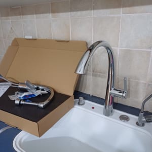 ברז חדש מותקן בכיור מטבח עם אריזת קרטון