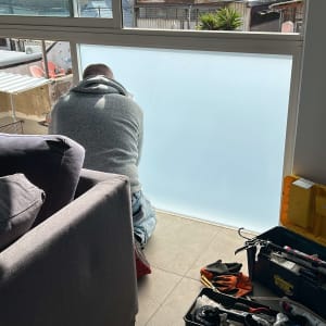 אדם עובד על התקנת זכוכית עם כלים מתאימים