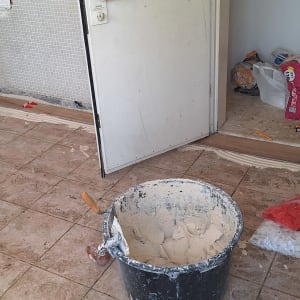 חדר בשיפוץ עם דלי טיח, אריחים וכלי עבודה