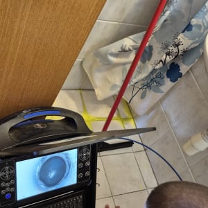 אדם משתמש במכשיר לאיתור נזילות בחדר אמבטיה