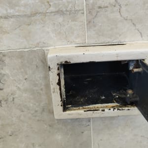 תיבת מתכת פתוחה בקיר עם סימני חלודה