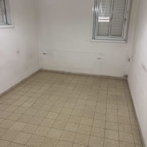 חדר ריק עם רצפת אריחים ותאורה עליונה
