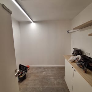 חדר עם כלים לעבודה על מדפים ותאורה