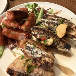 צלחת עם נקניקיות ולחם קלוי עם רוטב ועשבי תיבול