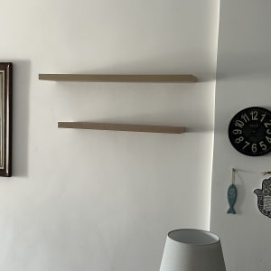 מדפים מותקנים על קיר עם מנורה ושעון