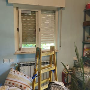 סולם ליד חלון עם תריסים בחדר