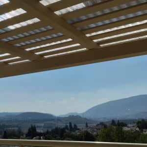 פרגולה מעץ עם גג שקוף חלקית