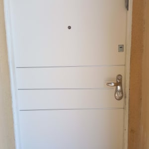 דלת לבנה עם ידית מתכת ומנעול