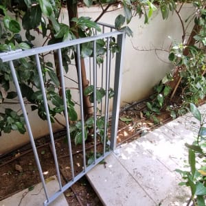 מסגרת מתכת אפורה בין שיחים ירוקים