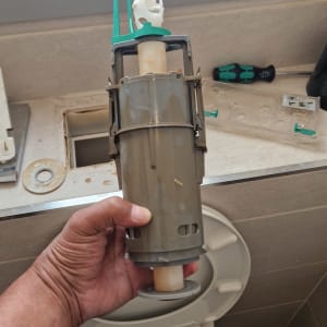 תיקון אסלה עם חלקי אינסטלציה וכלים