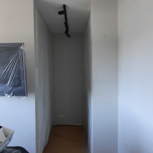 מסדרון עם רצפה מכוסה בנייר, קיר צבוע, תאורה מותקנת