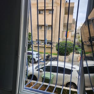 חלון עם סורגים כחולים מול בניין