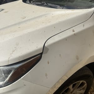 רכב מלוכלך עם כתמי בוץ על מכסה המנוע