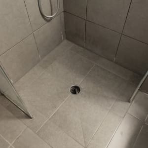 רצפת מקלחת מרוצפת עם ניקוז ומקלחת יד