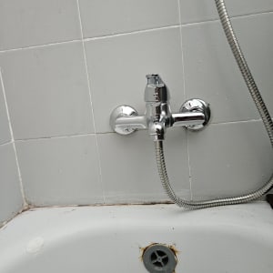 ברז אמבטיה עם צינור מתכת מחובר לקיר