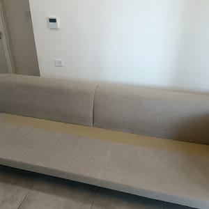 ספה אפורה עם סימני ניקוי על הרצפה