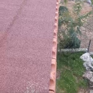 גג עם רעפים אדומים וצמחייה מסביב