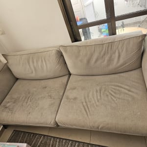 ספה עם כתמים ליד חלון גדול