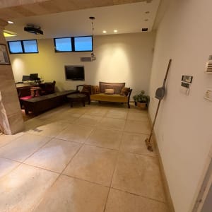 חדר עם ריהוט וספה, מטאטא על הקיר