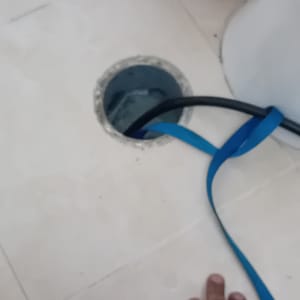 יד ליד פתח ניקוז עם צינור כחול ושחור