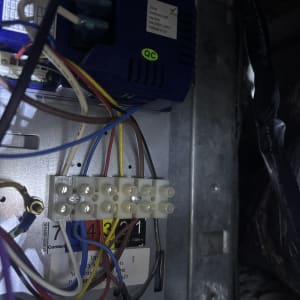 תמונת תקריב של חיבורי חשמל ולוח פיקוד במזגן במהלך עבודת תיקון