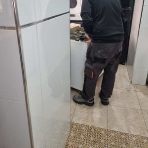 טכנאי עובד על מכשיר חשמלי במטבח קטן