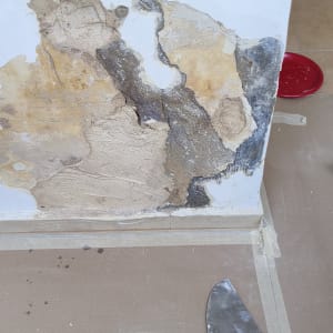 קיר מתקלף עם שפכטל על הרצפה