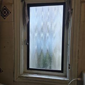 חלון עם זכוכית מט במבנה ישן