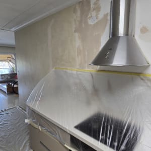 קיר במטבח עם עבודת צבע והגנה על משטחי עבודה