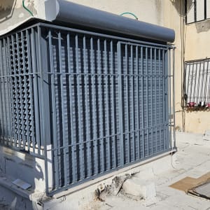 סורגים אפורים על חלון במבנה חיצוני