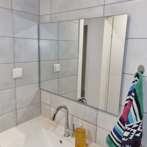 כיור עם ברז, מראה ומגבת צבעונית בחדר אמבטיה