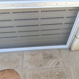 מסגרת אלומיניום עם רשת מתכת על קיר חיצוני