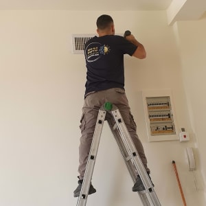 אדם על סולם מתקין מזגן על קיר