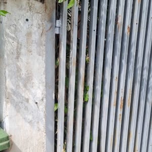 שער מתכת אפור עם עלים ירוקים מסביב