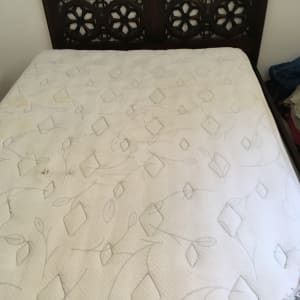 מזרן עם כתם קטן על רקע עץ כהה